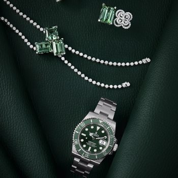 Photographie de joaillerie monochrome vert intense avec montre et bijoux sertis de diamants et pierres vertes.