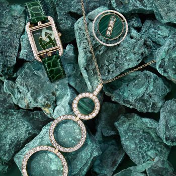 Photographie de bijoux de luxe sur fond monochrome vert, mettant en scène bague, montre et collier en pierres précieuses pour un magazine de joaillerie.